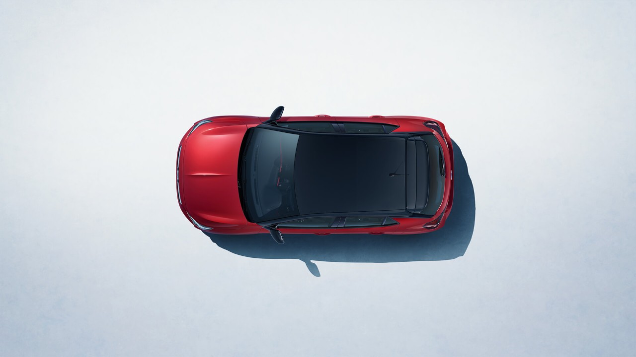 Ein roter Opel Corsa mit schwarzem Dach aus der Vogelperspektive