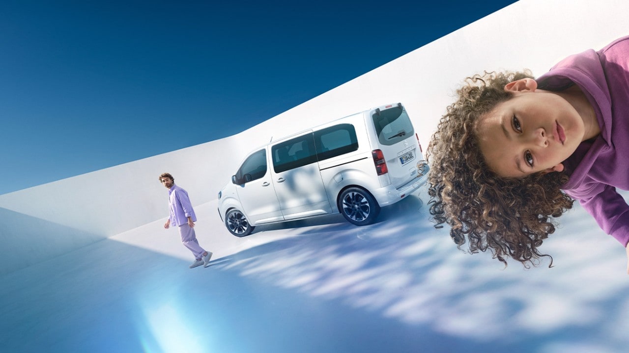  Kopf eines Kindes ragt ins Bild, ein Zafira Electric und ein Mann sind im Hintergrund zu sehen.